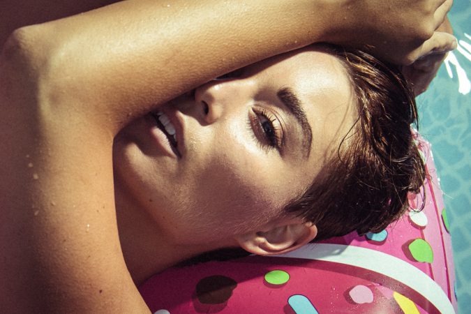 Frau Portrait im Pool Luftmatratze ungeschminkt natürlich Sonnenlicht