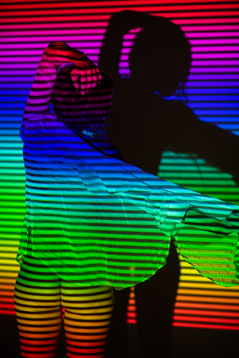 nackte Frau von regenbogenfarbigem Licht angestrahlt