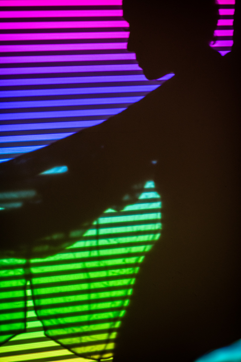 Siluette Frau von regenbogenfarbigem Licht angestrahlt